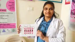 Meenakshi Gupta montre le diagramme mammaire avec les bandes de guidage dans sa salle d'examen.