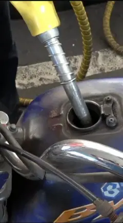 යතුරු පැදියක ටැංකියට ඉන්ධන පුරවන අයුරු මෙහි දැක්වේ.