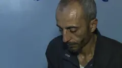 Reda al-Sayed looking down at a picture of his son