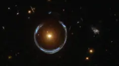 Imagem da distante galáxia Blue Horseshoe, ampliada pela galáxia Luminous Red à frente dela