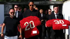 Virgil van Dijk y Andrew Robertson llevan coronas de flores con  los números 20 y 30