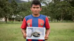 Germán Narankas, miembro de la comunidad shuar, muestra una de las especies que él y su comunidad descubrieron