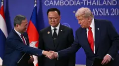 Presiden AS, Donald Trump, menyalami Perdana Menteri Kamboja, Hun Manet, yang disaksikan Perdana Menteri Thailand, Anutin Charnvirakul (tengah), pada Minggu (26/10). 