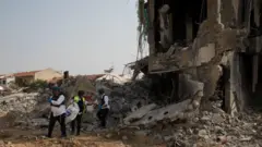 Israeli rescue members work at a police station that was destroyed after a battle between Israeli troops and Hamas militants on October 8, 2023 in Sderot, Israe