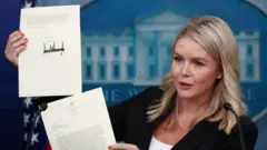 La secrétaire de presse de la Maison Blanche, Karoline Leavitt, montre une lettre signée par le président américain Donald Trump sur les droits de douane.