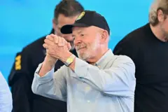 O presidente do Brasil, Luiz Inácio Lula da Silva, gesticula durante a cerimônia em Foz do Iguaçu. Ele usa camisa aul e boné preto