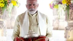 हातमा चाँदीको छतरी लिएका भारतीय प्रधानमन्त्री नरेन्द्र मोदी 