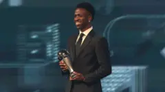 Vini Jr. segurando troféuquanto tempo demora o saque da galera betmelhor jogador do mundo da Fifa