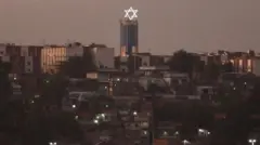 Imagem de casas no Complexo de Israel. A estrela de Davi está no alto de uma torre