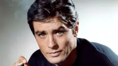 Alain Delon en una imagen de cerca fumando un cigarrillo.