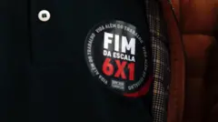 Close em um adesivo com a frase "fim da escala 6x1" em protesto em São Paulo MASP