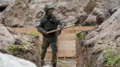 человек в камуфляже копает окоп