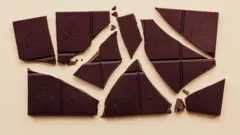 Bej bir arka plan üzerinde parçalara ayrılmış bir bitter çikolata