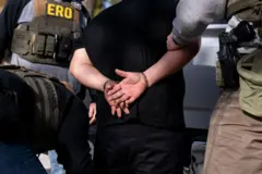 イリノイ州ライオンズのエージェントのグループによって手錠をかけられ、運転された反移民の襲撃で拘留された人。