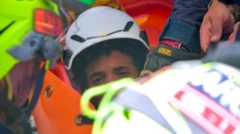 a imagem mostra metade do rosto do menino - o resto é obscurecido pelas equipes de resgate. Ele está usando um capacete branco e tem cabelo escuro encaracolado.