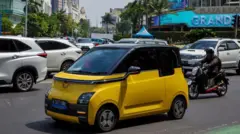 Sebuah mobil listrik melaju di jalan utama di Jakarta pada 7 Juni 2023.
