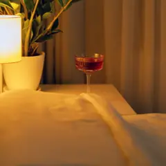 Taça de suco de cereja amarena na mesinha de cabeceira ao lado da cama