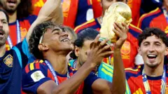Lamine Yamal sujeta la copa del mundo rodeado de jugadores de la selección española