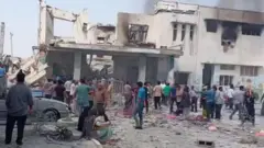 تصویری از محوطه بیرونی مدرسه که روز زمین آوار است و مردم نگران