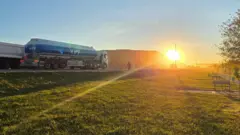 Caminhão com o logotipo da YPF viajando pela estrada ao amanhecer