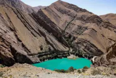 El agua azul brillante del embalse detrás de la presa Amir Kabir a lo largo del río Karaj en la cordillera de Alborz, en el norte de Irán, con altas montañas que lo rodean, el 1 de junio de 2025.