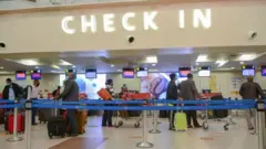 Tariki 31/7/2020: Abagenzi bambaye udupfukamunwa batonze umurongo ahagenzurirwa ibyangombwa ku kibuga mpuzamahanga cy’indege cya Jomo Kenyatta, i Nairobi muri Kenya 