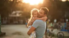 رجل يحتضن طفلة