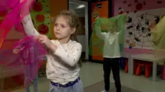 Дівчинка грається з шарфом