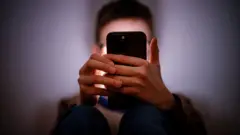 Молодой человек с мобильным телефоном, постановочное изображение