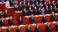 Los funcionarios chinos, incluido el presidente Xi Jinping en el centro de la imagen, permanecen junto a sus asientos en la sesión inaugural del Congreso Nacional del Pueblo celebrada en el Gran Salón del Pueblo en Pekín.