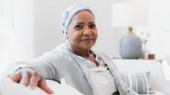 Mujer en un consultorio médico sentada en un sofá.