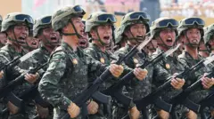 Vários militares fardados em fila segurando armas e gritando