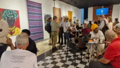 Varias personas sentadas en un espacio, conversando.