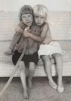 Foto en blanco y negro de los hijos de Daphne Larkin, Lucien y Zoe Markus, sentados en un sofá. En la foto se aprecia la traqueotomía de Lucien, quien estuvo con oxígeno durante los últimos seis años de su vida.