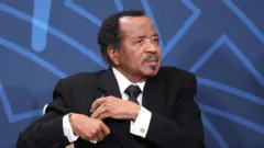 Cameroon president Paul Biya wear black suit wit white shirt