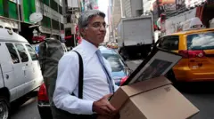 Funcionário do Lehman Brothers com caixas de papelão na rua