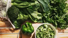 Pimentão, brócolis e outros vegetais verdes em cima de uma mesa