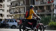 Residentes observan un edificio de apartamentos dañado tras un terremoto en Catia La Mar, estado de La Guaira, a unos 30 km al noroeste de Caracas, el 25 de junio de 2026.