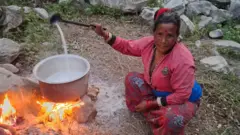 दूध तताउँदै महिला