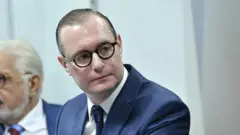 Cristiano Zanin Martins, um homem branco de óculos e terno