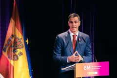 El presidente de gobierno español, Pedro Sánchez, en medio de una tarima con las banderas de España y la Unión Europea.