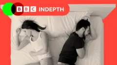 A woman and a man sleeping in bed back to back, top view