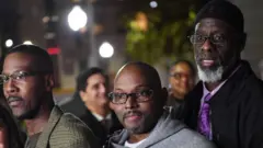 Lati apa osi, Alfred Chestnut, Andrew Stewart, ati Ransom Watkins ya fọto papọ lẹyin ti ile ẹjọ dawọn silẹ lori ipaniyan ti wọn ohun kan nipa rẹ lọdun 1983 ti wọn ṣẹwọn le lori