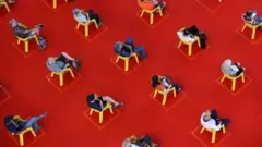 Pessoas sentadas em cadeiras amarelas