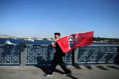 CHP bayrağı taşıyan bir adam İstanbul'da Haliç üzerindeki köprüden geçiyor - 4 Haziran 2015