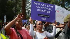 Abiyerekana bararirimba kandi bakavuza induru mu myiyerekano basaba ko ihohoterwa rishingiye ku gitsina n’ubwicanyi bukorerwa abagore vyotangazwa nk’ikiza mu gihugu, mu nyubakwa za Union Buildings i Pretoria kw’igenekerezo rya 11 Ndamukiza 2025.