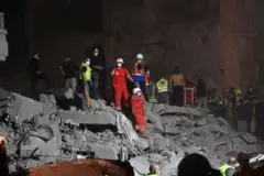 فرق الدفاع المدني تعمل على رفع الأنقاض، بينما يقف جنود الجيش اللبناني في حراسة موقع الغارة الإسرائيلية في منطقة البسطة الفوقا في بيروت.
