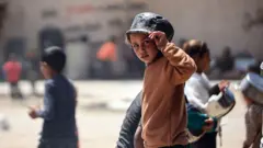 طفل يضع وعاء على رأسه في غزة