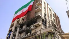 Edificio residencial con una gran bandera iraní, alcanzado por un ataque israelí en Teherán el 25 de junio de 2025.