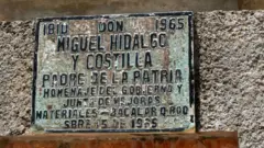 Una placa vieja y desgastada reconoce a Miguel Hidalgo como "Padre de la Patria".